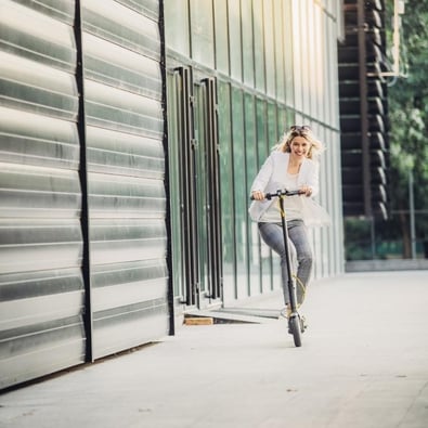 Business woman riding a scooter