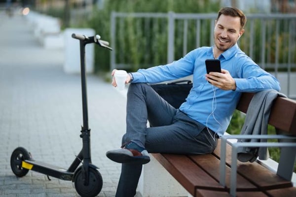 Man on the phone with an e-scooter